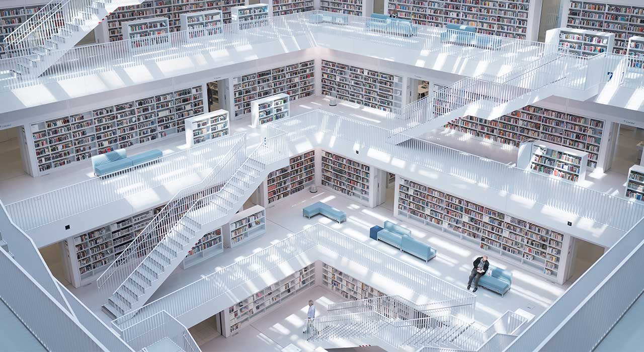 Interior de uma grande biblioteca com design clean e branco representa a aposta na inovação e digitalização